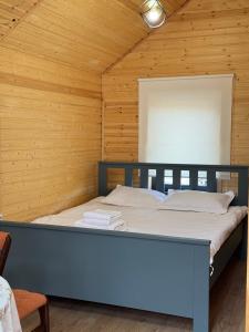 ein Bett in einem Zimmer mit einer Holzwand in der Unterkunft Mountain View - Kolsay in Kurmenty