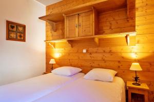 尚帕尼恩瓦努瓦茲Pralioud – Confort moderne, spa & piscine的一间木墙房间里有两张床 更多18张照片