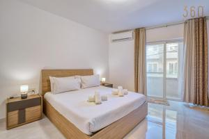 Un dormitorio con una cama grande y una ventana grande en Beautiful 3BR homes with comfy beds, WIFI & AC by 360 Estates, en Naxxar