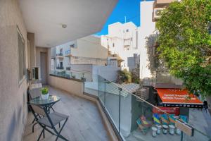 balcón con mesa y vistas a los edificios en Beautiful 3BR homes with comfy beds, WIFI & AC by 360 Estates, en Naxxar
