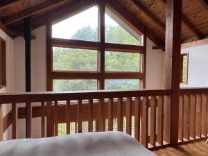 Cabin B vacation house rental Mt Fuji View 3 min lake Saiko 5min drive Lake Kawaguchi في فوجيكاواجوتشيكو: غرفة نوم بها سرير ونافذة كبيرة