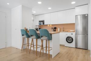 卡拉德米哈斯Casa Linda - Luxury home in La Cala de Mijas的厨房配有白色橱柜和位于柜台的蓝色椅子 更多34张照片