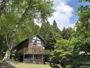 Cabin B vacation house rental Mt Fuji View 3 min lake Saiko 5min drive Lake Kawaguchi في فوجيكاواجوتشيكو: كابينة خشب في الغابة بها أشجار