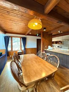 Cabin B vacation house rental Mt Fuji View 3 min lake Saiko 5min drive Lake Kawaguchi في فوجيكاواجوتشيكو: غرفة طعام مع طاولة وكراسي خشبية