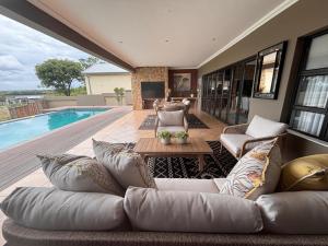 un salon avec un canapé et une piscine dans l'établissement Euphoria Self Catering Home, à Naboomspruit