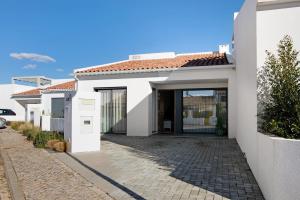 a white house with a driveway at Casa do Sol and Golf - Vilamoura in Estibeira