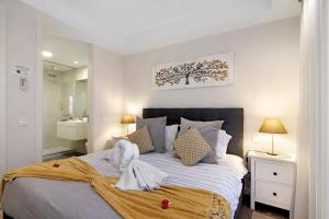 a bedroom with a bed with towels on it at Casa do Sol and Golf - Vilamoura in Estibeira +21 photos