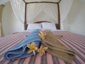 a group of towels and flowers on a bed at Homestay & Restaurant Segara Amed in Amed +34 photos