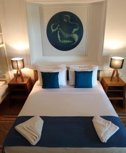 ein Schlafzimmer mit einem großen weißen Bett mit blauen Kissen in der Unterkunft IslandOnBolgoda in Piliyandala