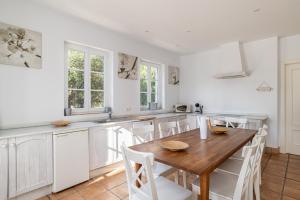 eine Küche mit einem Holztisch und weißen Schränken in der Unterkunft Villa Albatros in Benalup Casas Viejas