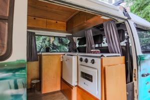 伊塔蒂巴Quinta do Vale - Kombi Home Varanda, vista Lago, piscina, cascata的房车内的厨房，配有炉灶