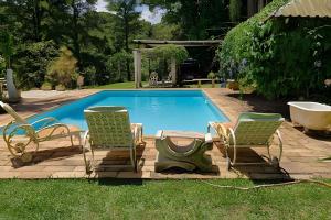 伊塔蒂巴Quinta do Vale - Kombi Home Varanda, vista Lago, piscina, cascata的一个带两把躺椅和一个浴缸的游泳池