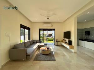 Stay Leisurely Casa Astre 3BHK, Karjat في كارجات: غرفة معيشة بها أريكة وطاولة