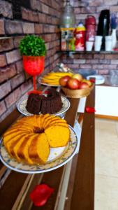 伊塔蒂巴Quinta do Vale - Kombi Home Varanda, vista Lago, piscina, cascata的桌子上有三盘食物 更多21张照片