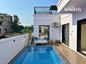 Stay Leisurely Casa Astre 3BHK, Karjat في كارجات: منزل مع مسبح في الحديقة الخلفية