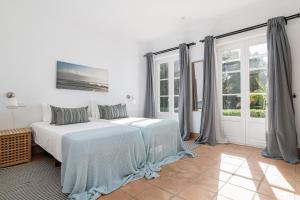 ein weißes Schlafzimmer mit einem Bett und einem Fenster in der Unterkunft Villa Albatros in Benalup Casas Viejas