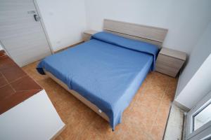 a small bedroom with a blue bed in a room at Max in Condofuri