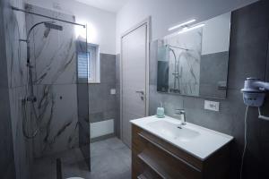 a bathroom with a sink and a shower with a mirror at Max in Condofuri +52 photos
