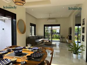 Stay Leisurely Casa Astre 3BHK, Karjat في كارجات: غرفة طعام مع طاولة وغرفة معيشة