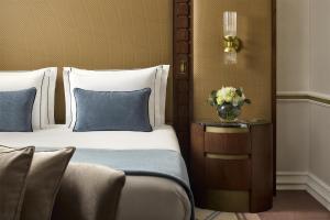 een slaapkamer met 2 bedden en een vaas met bloemen op een tafel bij Tivoli Avenida Liberdade Lisboa – A Leading Hotel of the World in Lissabon