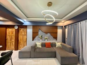 a living room with a couch and a chandelier at Baguio Transient Across Burnham Park 2 - 2BR Condo in Baguio