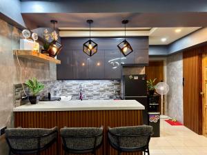 una cocina con barra con sillas y mostrador en Baguio Transient Across Burnham Park 2 - 2BR Condo, en Baguio