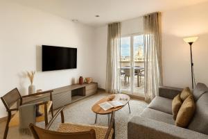 ein Wohnzimmer mit Sofa und Fernseher in der Unterkunft The Corner Apartments by Aspasios in Barcelona