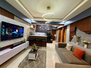 a living room with a large tv and a couch at Baguio Transient Across Burnham Park 2 - 2BR Condo in Baguio