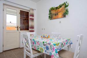 - une table avec un chiffon de table de bonjour dans l'établissement Apartments Antonio, à Duće