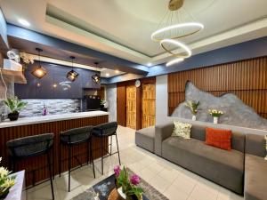 Una sala de estar con un sofá y un bar. en Baguio Transient Across Burnham Park 2 - 2BR Condo, en Baguio