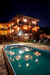 una casa con una piscina di fronte ad essa di notte di Pousada Província a Lavras Novas