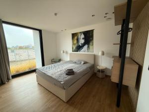 a bedroom with a bed and a large window at Ferienwohnung Zwischenzeit in Kranenburg