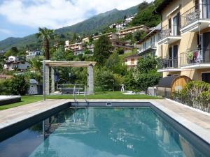 a swimming pool in front of a building at Casa Ghiggi Ticino in Brissago