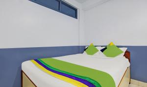 a bedroom with a bed with a rainbow blanket at Itsy Hotels Shillong Tower Guesthouse in Shillong