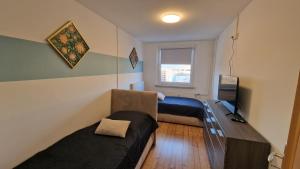 a room with two beds and a desk and a window at Stadtblick Annaberg Große Fewo Peter 5 Personen in Annaberg-Buchholz