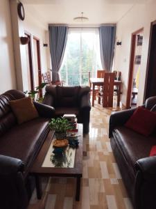 a living room with leather couches and a table at Kelum Homestay in Kandy