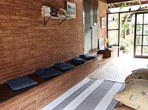 a brick wall with blue pillows on it at Recanto Marazul in Ubatuba