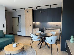 a kitchen and living room with a table and chairs at Apartament Wileńska 2 in Słupsk