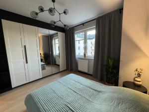 a bedroom with a bed and a large mirror at Apartament Wileńska 2 in Słupsk