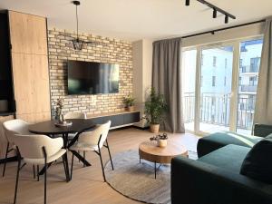 a living room with a couch and a table at Apartament Wileńska 2 in Słupsk
