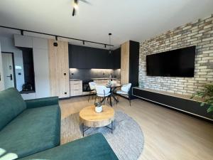 a living room with a couch and a table at Apartament Wileńska 2 in Słupsk +3 photos