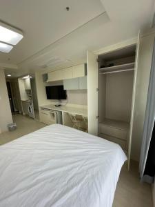 a bedroom with a white bed and a desk at 트루엘 레지던스 in Seogwipo