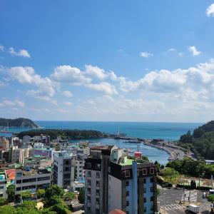 a view of a city with the ocean and buildings at 트루엘 레지던스 in Seogwipo