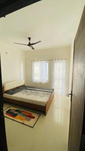 哥印拜陀Urban Stay - minimalist 2BHK near to Airport的一间卧室，里面有一张床和一个吊扇