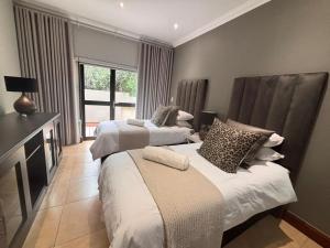 une chambre avec deux lits et une fenêtre dans l'établissement Euphoria Self Catering Home, à Naboomspruit 17 autres photos