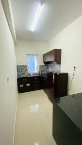 哥印拜陀Urban Stay - minimalist 2BHK near to Airport的厨房配有黑色橱柜和黑色台面