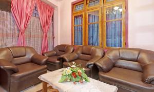 a living room with leather furniture and a table at Itsy Hotels Shillong Tower Guesthouse in Shillong