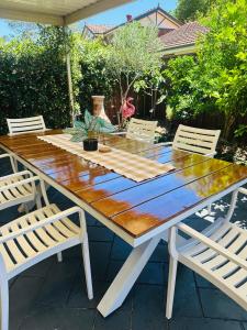 - une table de pique-nique en bois avec 2 chaises sur la terrasse dans l'établissement Southern Sky Villa, à Ingleburn