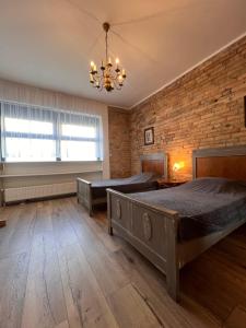 a bedroom with two beds and a brick wall at Louis Apartaments in Skorka +6 photos
