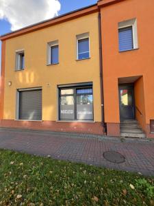 a orange building with windows and a sidewalk at Louis Apartaments in Skorka